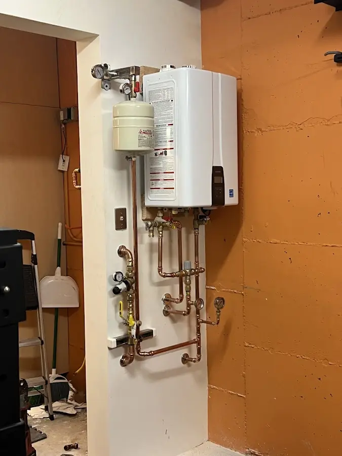 Plumbing technician inspecting water heater connections in Eudora